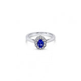 18ct white gold ring featuring a 0.45ct oval cut tanzanite surrounded by twelve round brilliant cut diamonds in an elegant oval cluster design.