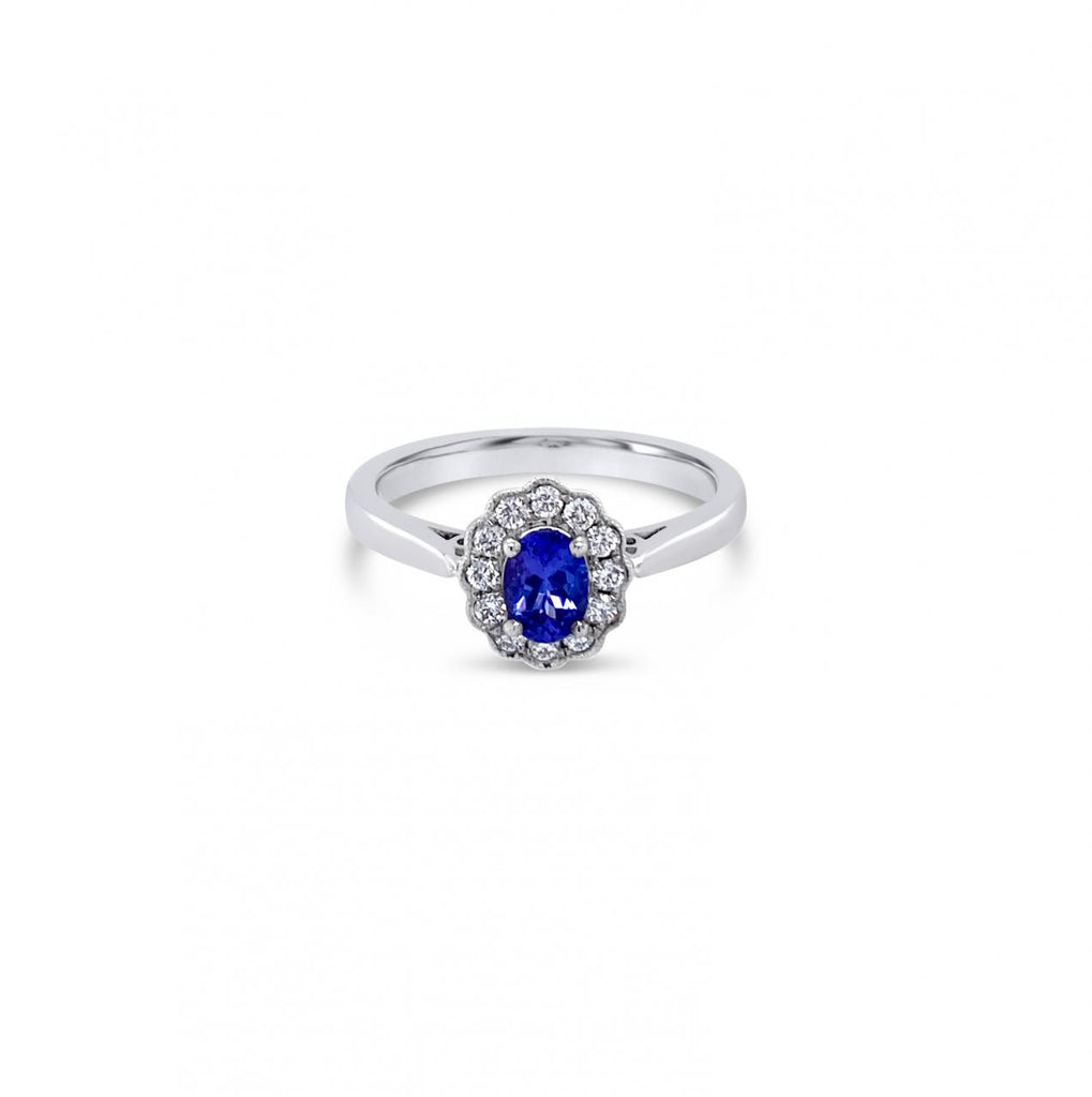 18ct white gold ring featuring a 0.45ct oval cut tanzanite surrounded by twelve round brilliant cut diamonds in an elegant oval cluster design.