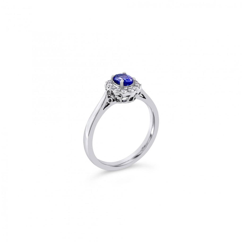 18ct white gold ring featuring a 0.45ct oval cut tanzanite surrounded by twelve round brilliant cut diamonds in an elegant oval cluster design.
