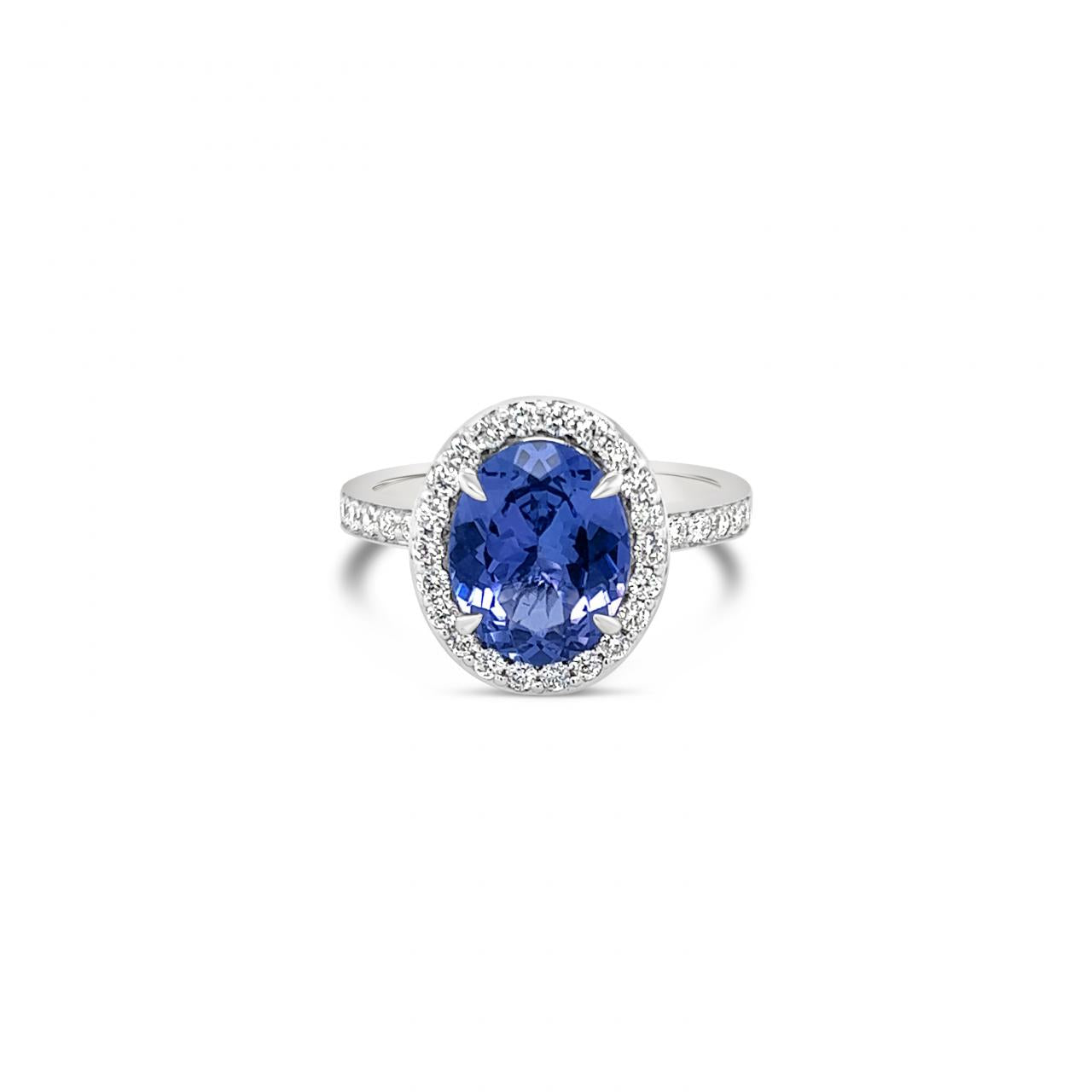 18ct white gold ring featuring a 2.30ct oval cut tanzanite surrounded by a halo of 34 round brilliant cut diamonds with diamond-set shoulders.