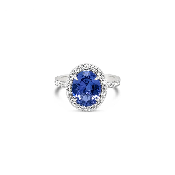18ct white gold ring featuring a 2.30ct oval cut tanzanite surrounded by a halo of 34 round brilliant cut diamonds with diamond-set shoulders.