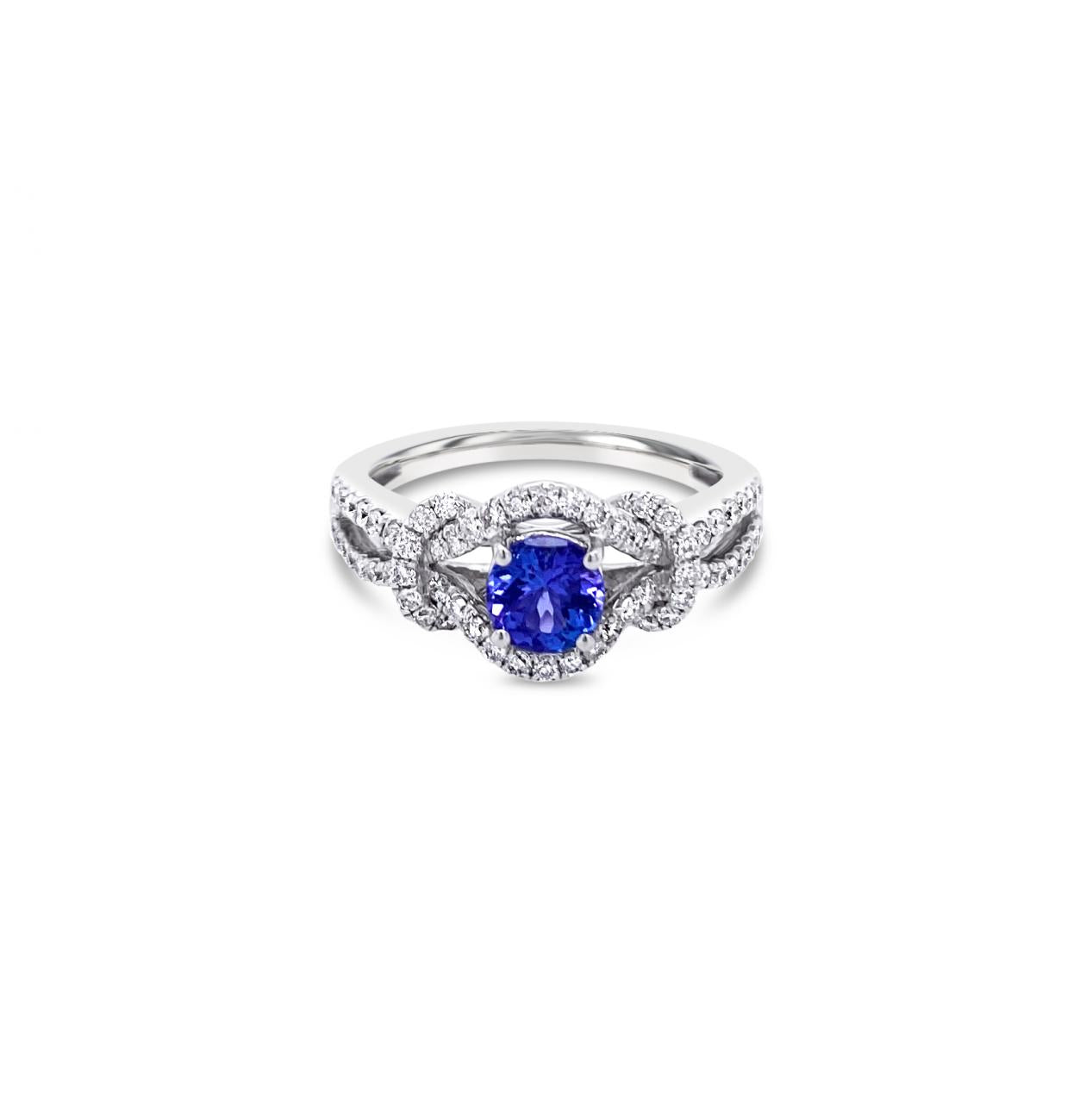 18ct white gold ring featuring a 0.52ct tanzanite surrounded by 64 round brilliant cut diamonds in an elegant claw-set design.