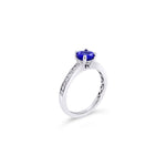 18ct white gold ring with round tanzanite and channel-set diamond shoulders.